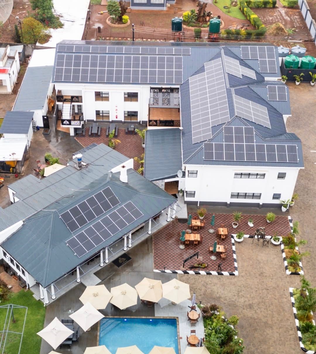 Commercial hotel complex with multi-roof solar installation — aerial